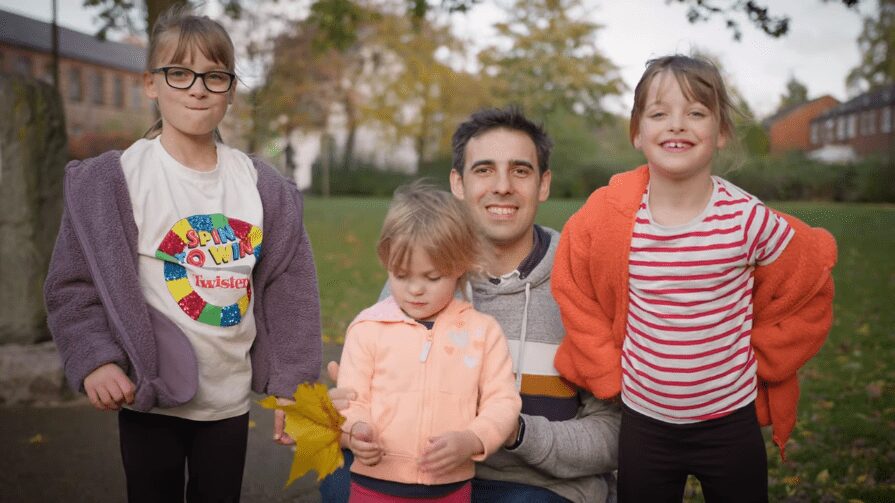 A still of a charity video production manchester film. Devoted father David and his three daughters pose for a photograph, while finding solace and support at Beechwood Cancer Care following tragic loss.